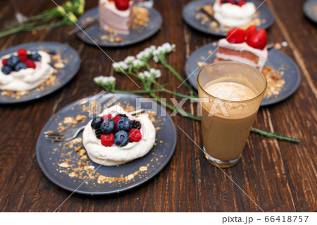 Sweet cakes with summer berries on a wooden table. 66418757