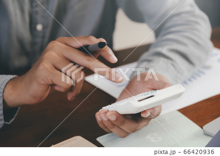 Closeup accountant using calculator. 66420936