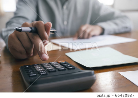 Closeup accountant using calculator. 66420937