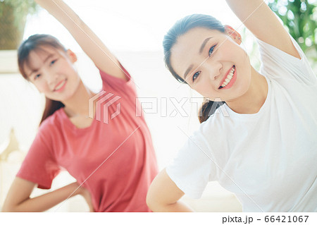 Two woman doing exercise at home Two woman doing exercise at home 66421067