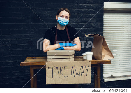 Woman preparing drinks and meals, wearing protective face mask and gloves. Contactless delivery service during quarantine coronavirus pandemic. Take away only concept. 66421091