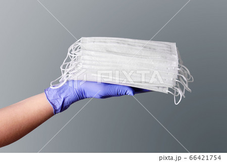 Medical fase masks on a hand in glove Medical fase masks on a hand in glove 66421754