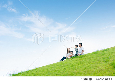 草原に座って談笑する家族 66423844