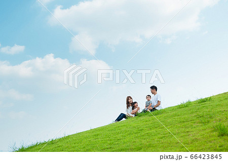 草原に座って談笑する家族 66423845