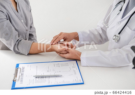 The doctor examines the patient's pulse by hand and records the results 66424416