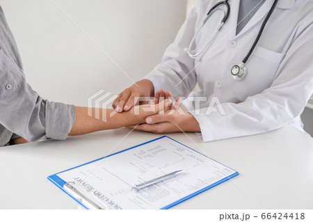 The doctor examines the patient's pulse by hand and records the results 66424418