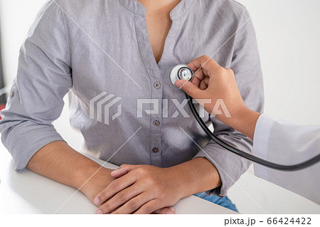 Doctor evaluates the patient with a stethoscope, blood pressure monitor and records the results Doctor evaluates the patient with a stethoscope, blood pressure monitor and records the results 66424422