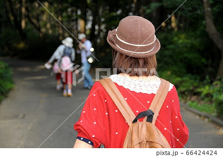 前を行く家族見て、笑みが毀れる、後姿の女の子 66424424