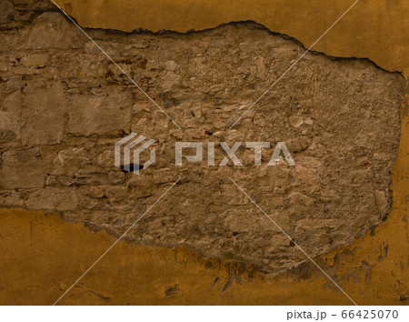 Old brick or stone wall with fallen stucco. Grunge texture of antique architecture. Abstract frame or background Old brick or stone wall with fallen stucco. Grunge texture of antique architecture. Abstract frame or background 66425070
