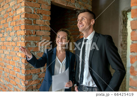 Cute broker showing the new construction to investor 66425419