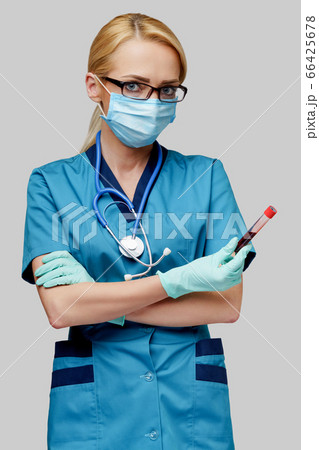 medical doctor nurse woman wearing protective mask and gloves - holding virus blood test tube medical doctor nurse woman wearing protective mask and gloves - holding virus blood test tube 66425678