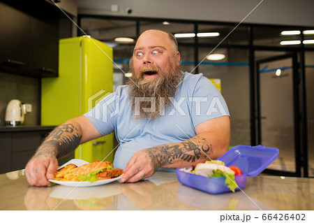Funny cheerful overweight bald man choosing food Funny cheerful overweight bald man choosing food 66426402