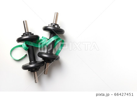 Sport black dumbbells and measuring tape on grey 66427451