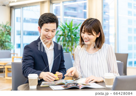 資料を見て社内旅行の計画を立てる男女 66428084