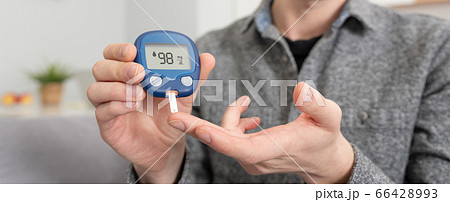 Young man measures blood sugar level. 66428993
