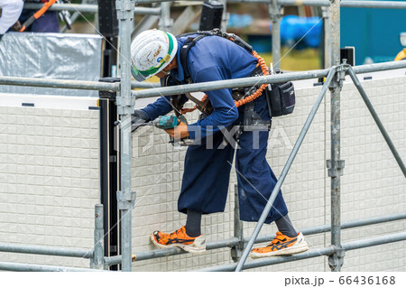 小雨が降る中プレハブ住宅を組み立てる男性作業員 小雨が降る中プレハブ住宅を組み立てる男性作業員 66436168