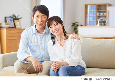 リビングのソファーに座るカップルの写真素材