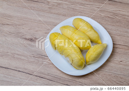 Fresh durian fruit placed on a white plate.  66440895