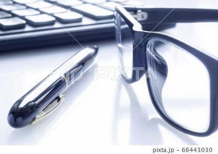 Stylish black business glasses, pen and calculator on white 66443030