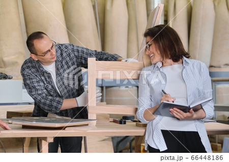 Furniture joinery production, working male joiner and female business owner with notebook Furniture joinery production, working male joiner and female business owner with notebook 66448186