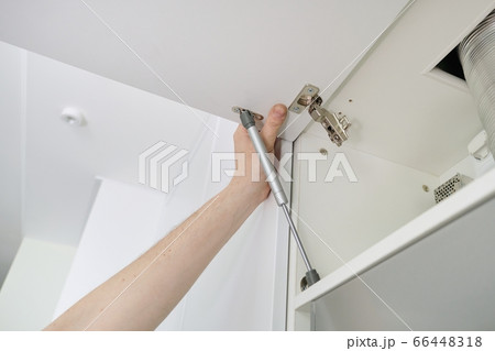 Installation of furniture. Closeup of workers hand and furniture details Installation of furniture. Closeup of workers hand and furniture details 66448318