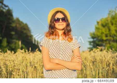 Summer portrait of teenage girl with folded arms in wheat field 66449109