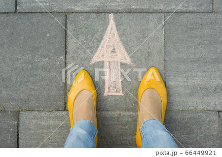 Female feet with arrow painted on the grey sidewalk Female feet with arrow painted on the grey sidewalk 66449921