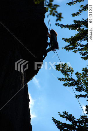 Silhouette of female alpinist climbing mountain. Silhouette of female alpinist climbing mountain. 66451015