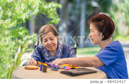 Elderly woman with caregiver in the needle crafts Elderly woman with caregiver in the needle crafts 66452417