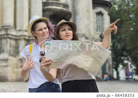 Women tourists mother and daughter teenager with map Women tourists mother and daughter teenager with map 66458353
