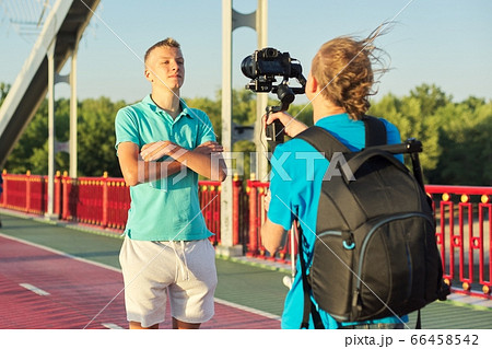 Boy teenager model and male photographer taking photos videos with camera and stabilizer 66458542