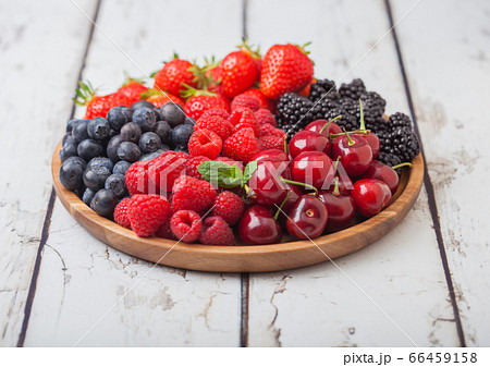 Fresh organic summer berries mix in round wooden Fresh organic summer berries mix in round wooden 66459158