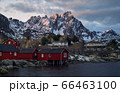 Classic red rorbu next to mountain ranges in Ballstad, Lofoten island, Norway 66463100