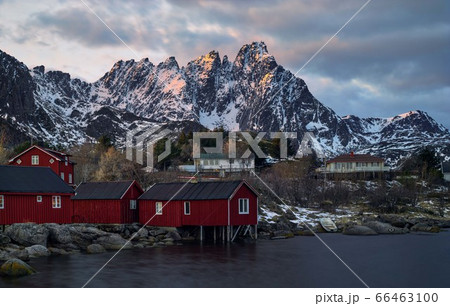 Classic red rorbu next to mountain ranges in Ballstad, Lofoten island, Norway Classic red rorbu next to mountain ranges in Ballstad, Lofoten island, Norway 66463100