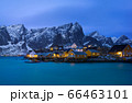 Classic illuminated yellow waterfront rorbu in Reine, Lofoten island, Norway 66463101