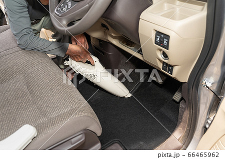コードレスクリーナーで車内清掃 前部座席 運転席の写真素材