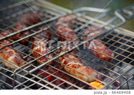 Hot sausage grilling outdoors on a barbecue grill. 66469408