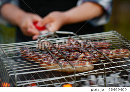 Hot sausage grilling outdoors on a barbecue grill. 66469409
