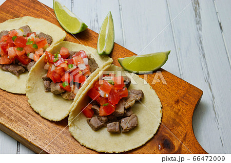 サルサ・メヒカーナをかけたメキシコ料理のタコス（コピースペースあり） 66472009