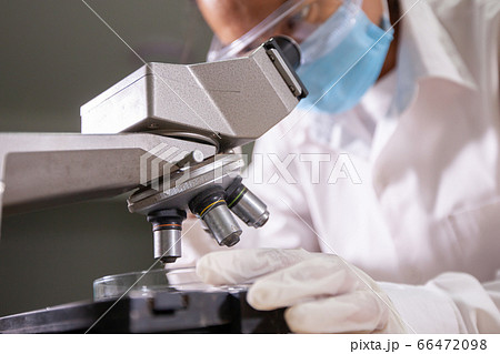 Asian scientist looking through a microscope for research and analysis chemical test in laboratory Asian scientist looking through a microscope for research and analysis chemical test in laboratory 66472098