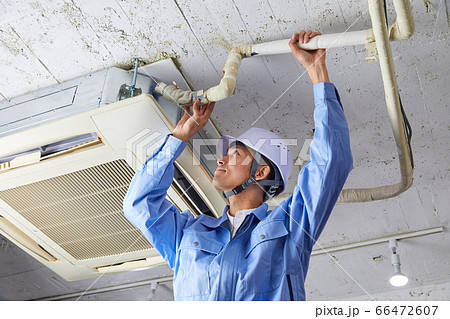 業務用エアコンの修理をする作業服を着たビジネスマン 業務用エアコンの修理をする作業服を着たビジネスマン 66472607