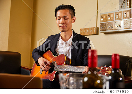 ギターを弾く若い男性 66473910