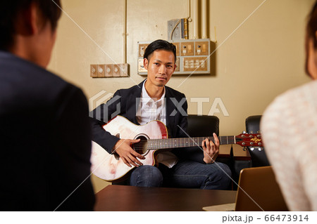 ギターを弾く若い男性 66473914