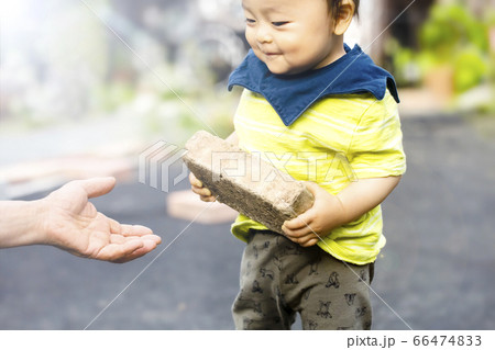 がんばって重いレンガを持って行ってあげようとする男の子と大人の手 がんばって重いレンガを持って行ってあげようとする男の子と大人の手 66474833