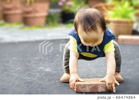 重いレンガを持ち上げようとしている健気でかわいい子供の姿 66474864
