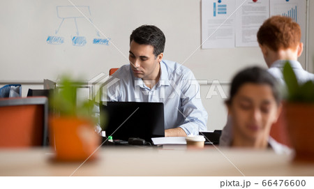 Serious busy businessman employee working on laptop in coworking space Serious busy businessman employee working on laptop in coworking space 66476600