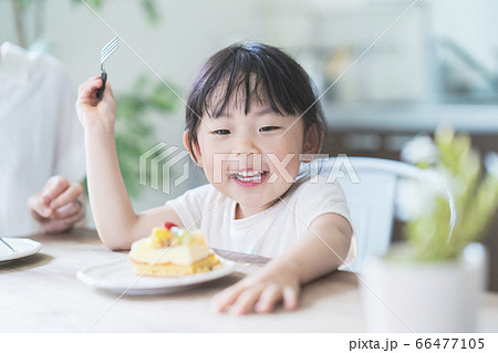 部屋のテーブルでケーキを食べる親子 66477105