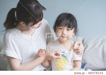 母親に体温を計測してもらう女の子 66478143