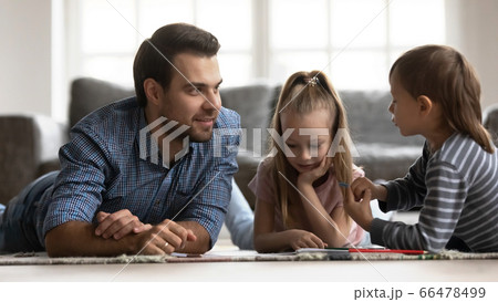 Smiling father with little kids playing on warm floor 66478499