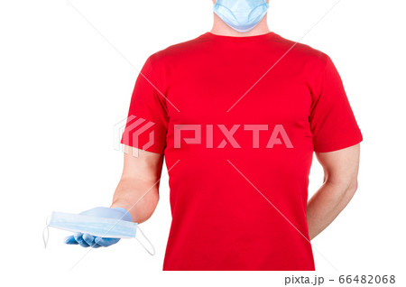 Man in red t-shirt holding disposable face mask isolated white background Man in red t-shirt holding disposable face mask isolated white background 66482068